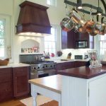 Kitchen with pots and pans hanging over a white island