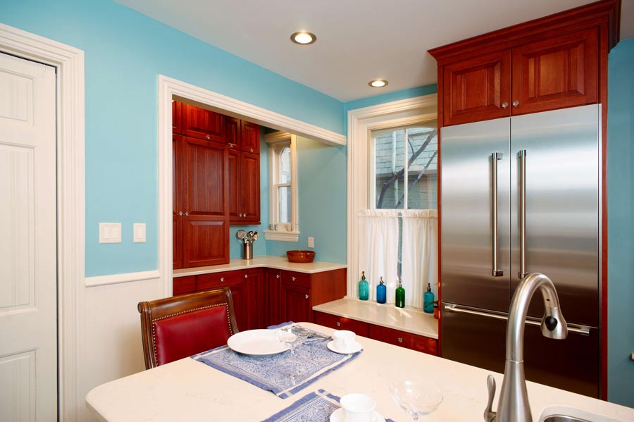 traditional blue kitchen with cherry custom cabinets and white tile backsplash designed by morris black designs