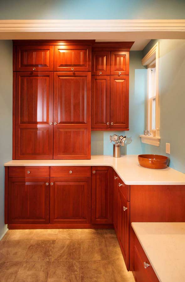 cherry custom cabinetry built into alcove in traditional blue kitchen design by morris black designer Dan