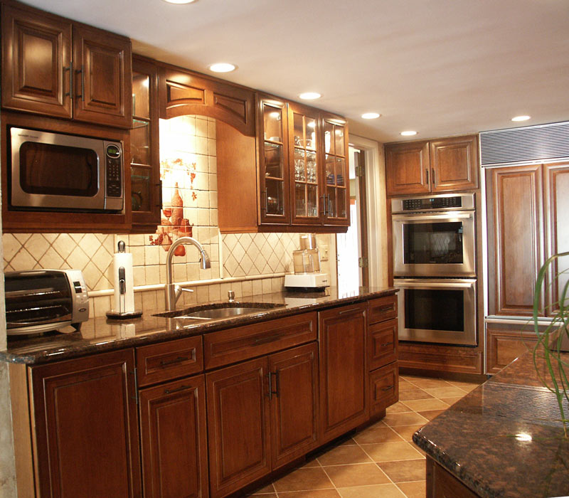 traditional galley kitchen with double wall ovens and cherry kraftmaid kitchen cabinets by morris black designs