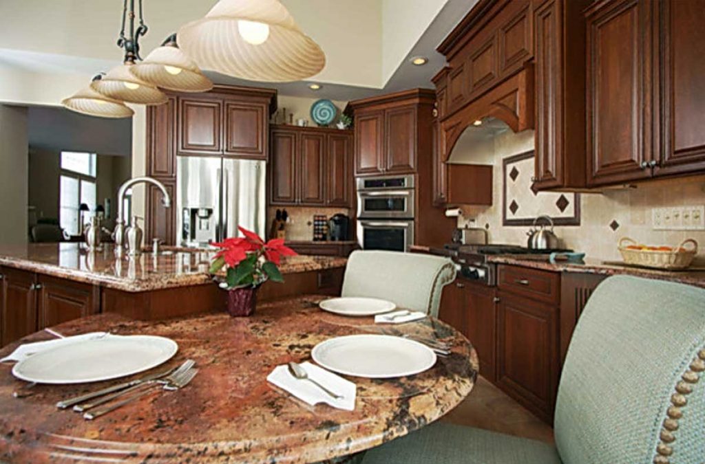 Beautiful Old World Influenced Kitchen with extended granite island top and blue chairs in Macungie Pennsylvania.