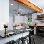 The stainless steel appliances, pendant lights, and granite countertops