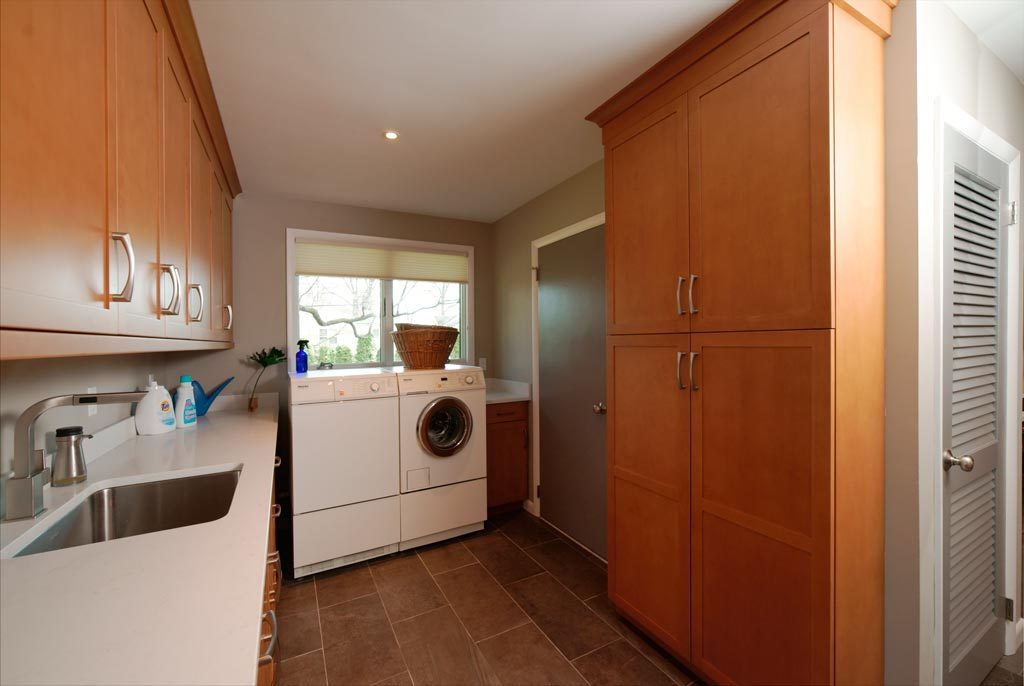 laundry room with light wood cabinetry, washer, dryer, and undermount sink Allentown, PA