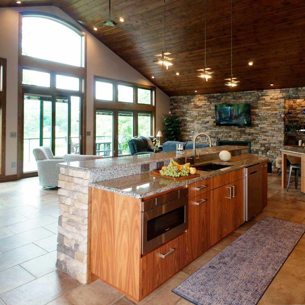 contemporary stone kitchen that is open to the living room with a large floor to ceiling window
