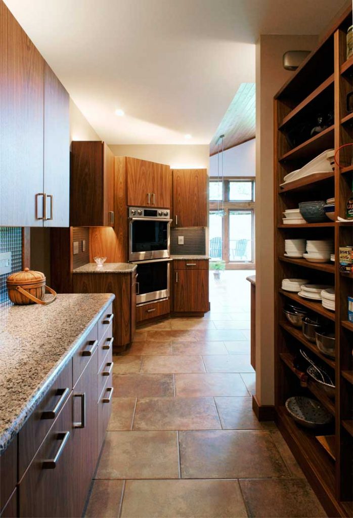 contemporary stone kitchen with a large pantry with floating shelves