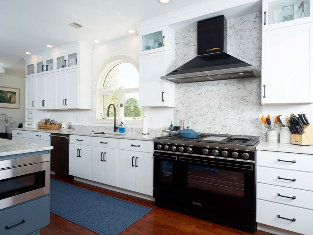 Sea Salt Kitchen Cabinets with Black Hardware and a Galley Sink