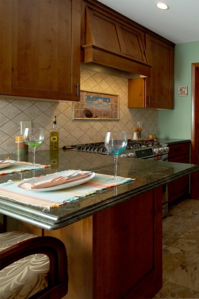 Kitchen Peninsula with Green Granite Counters and Knotty Alder Chestnut Stained Wood Cabinets